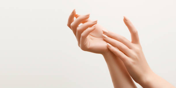 belle mani da donna. mani femminili che applicano crema, lozione. concetto spa e manicure. mani femminili con manicure francese. pelle morbida, concetto di cura della pelle. cura della pelle delle mani. - fingernail human finger clean human thumb foto e immagini stock