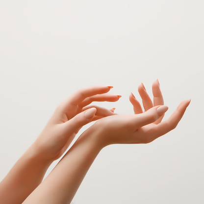 Closeup image of beautiful woman's hands with light pink manicure on the nails. Skin care for hands, manicure and beauty treatment. Elegant and graceful hands with slender graceful fingers