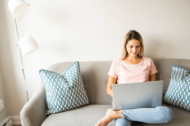 istock woman with a laptop on sofa at home 1070534574