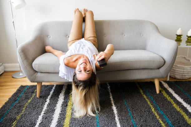 istock Beautiful woman relaxing on a sofa with head upside 1070534800