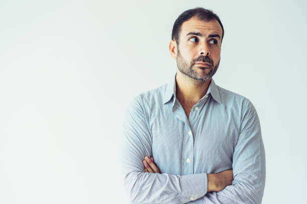 istock Pensive puzzled Latin man with crossed arms looking aside 1070539642