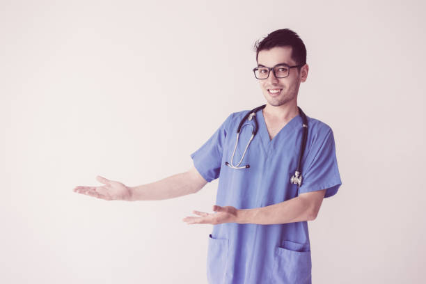 istock Happy male doctor pointing at empty space and presenting product 1070539676