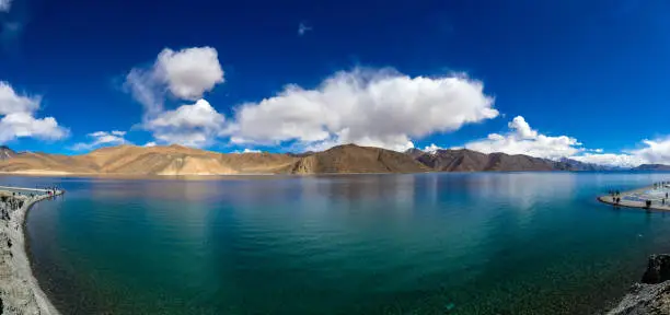 Panorama view of Pangong Lake or Pangong Tso in the Himalayas and mountain view, blue sky background.