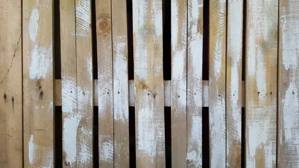 Old wooden fence stained with white paint