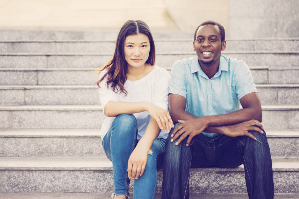 istock Portrait of smiling multiethnic students sitting on staircase 1070544618