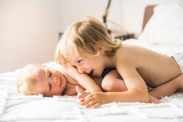istock baby in bed with his brother son 1070558828