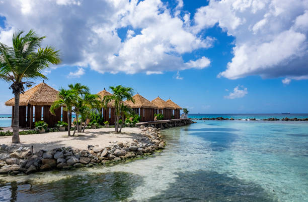 Picturesque Renaissance Islands of Aruba Picturesque Renaissance Islands of Aruba with Turquoise Waters, Swaying Palm Trees and Private Gazebos pretty beach house stock pictures, royalty-free photos & images