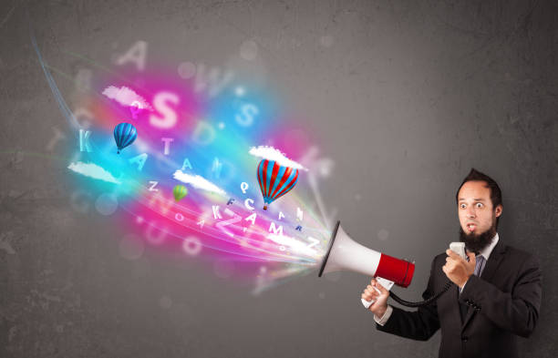 istock Man shouting into megaphone and abstract text and balloons come out 1070574960