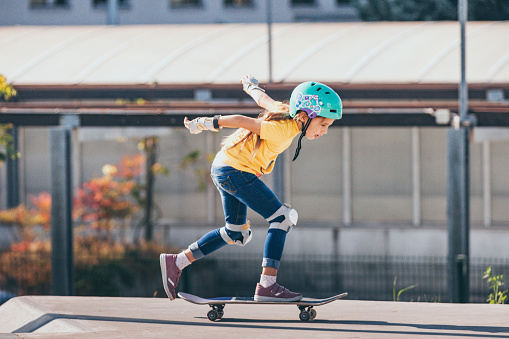 Young Girl Riding a Skateboard Outdoors.