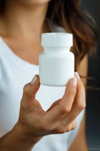 istock Hispanic young woman holding a white plastic medicine bottle 1070600030