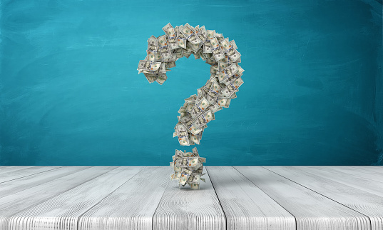 3d rendering of a question sign made of many dollar banknotes hanging above a wooden desk. Where are money. How to get rich. Question of money.
