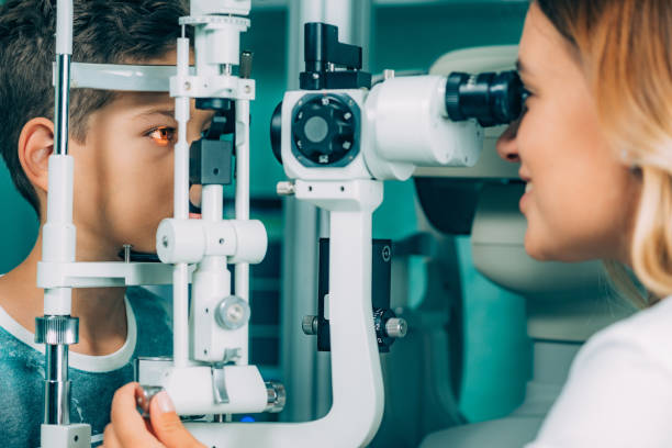 istock Eye Exam. Ophthalmology, slit lamp exam, school boy having his eye sight checked 1070605908
