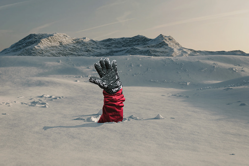 Excursionista extendiendo su mano de nieve a la ayuda de la señal debido a la avalancha de la nieve. Concepto de extremo peligro photo