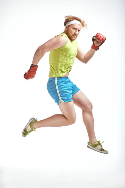 istock Red haired, bearded, plump man jumps in red boxing gloves 1070619366