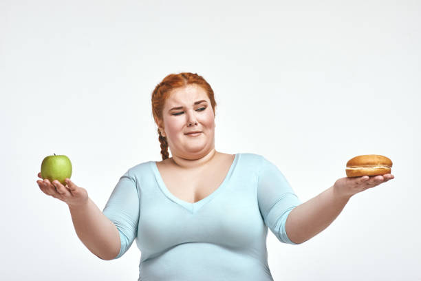 istock Red haired, chubby woman is choosing between apple and sandwich 1070619542