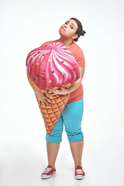 istock Brunette, chubby woman is holding a huge ice cream 1070619884
