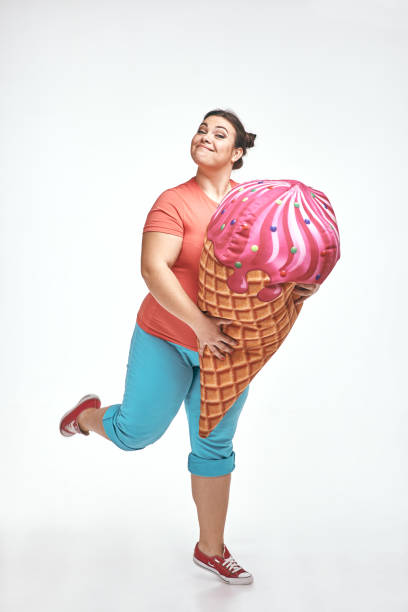 istock Brunette, chubby woman is holding a huge ice cream 1070620358