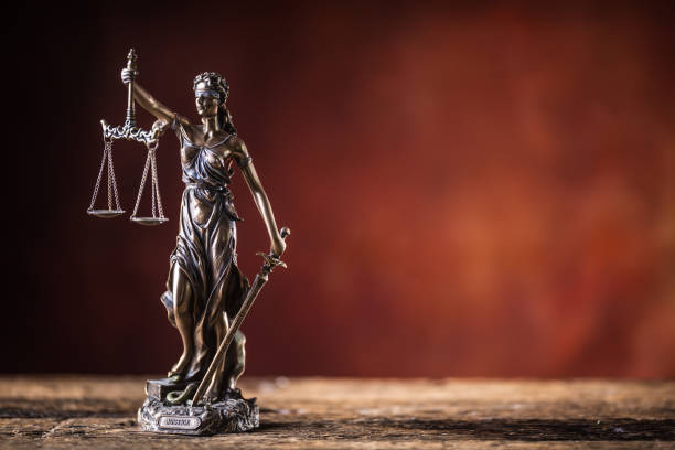 señora justicia holding espada y balanza de bronce estatuilla en mesa de madera. - iustitia fotografías e imágenes de stock