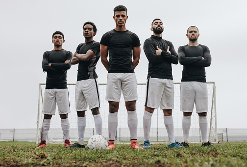 Futbolistas de pie lado a lado en un campo de fútbol photo