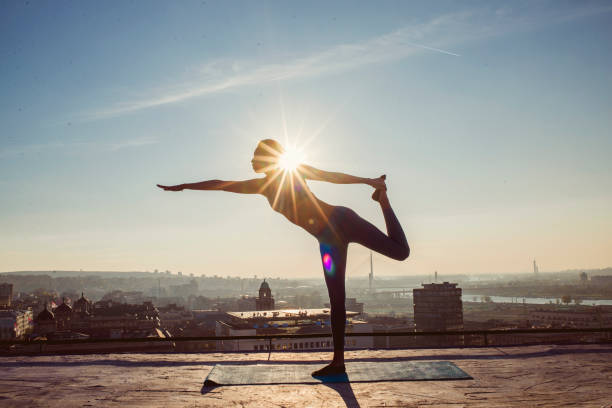 istock woman doing yoga on the rooftop 1070632024