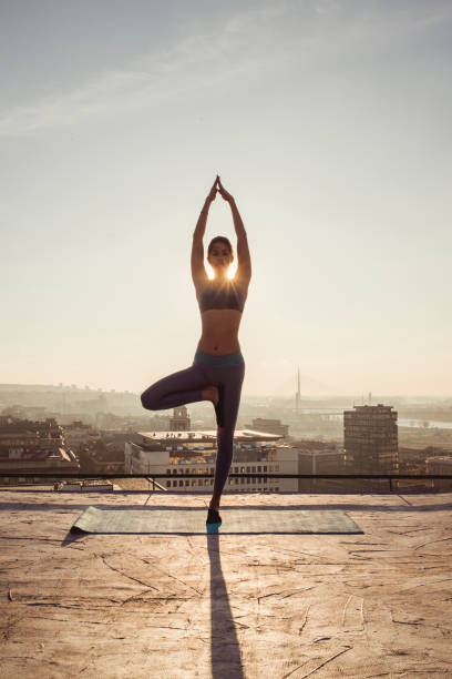 istock woman doing yoga on the rooftop 1070633344
