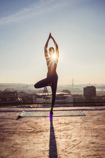 istock woman doing yoga on the rooftop 1070633384
