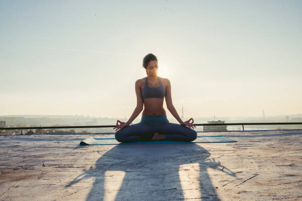 istock woman doing yoga on the rooftop 1070634494