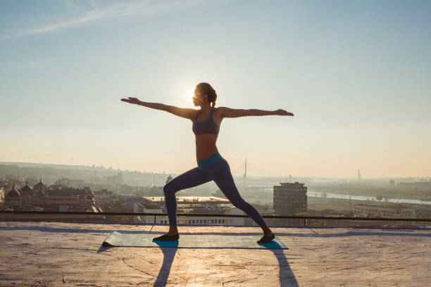istock woman doing yoga on the rooftop 1070634914