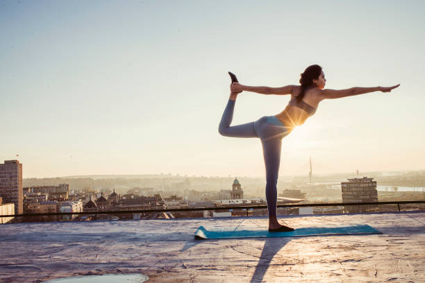 istock woman doing yoga on the rooftop 1070635342