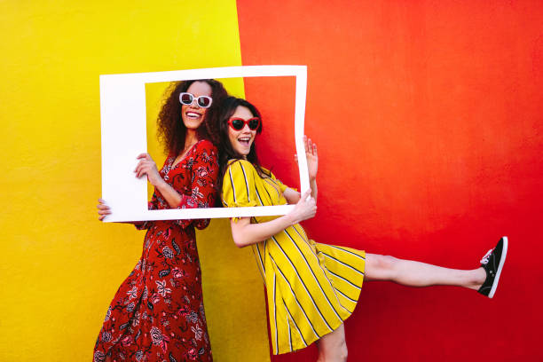 istock Excited girl friends with empty photo frame 1070639314