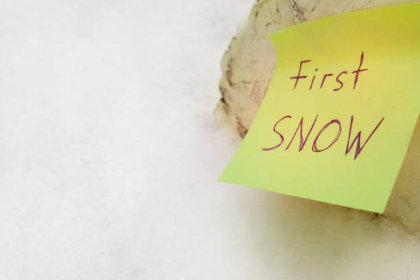 istock first snow - handwritten inscription on yellow ssticky note 1070639744