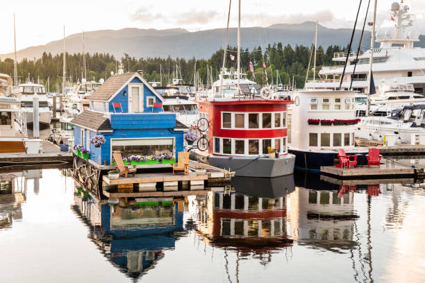 Photo of Colourful Wooden Houseboats Moored in a Harbour at Sunset. Reflection in Water. Vancouver, BC, Canada.