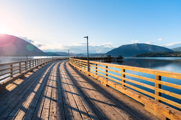 istock Spring Sunset over a Wooden Pier on a Lake Surrounded by Forested Mountains 1070646480