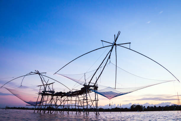 Silhouette of square dip nets with sunrise sky background, livelihoods of fishermen Silhouette of square dip nets with sunrise sky background, livelihoods of fishermen at Pakpra, Phattalung in Thailand phatthalung province stock pictures, royalty-free photos & images