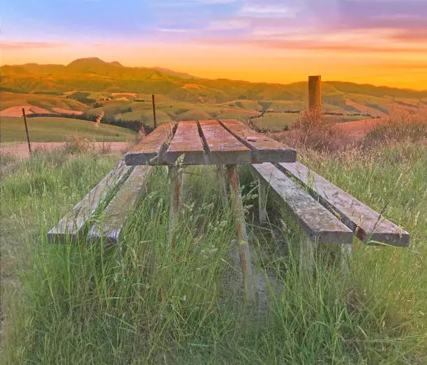 Digital Watercolor Painting, Beautiful twilight picturesque farmland view of Middle Valley, Canterbury, New Zealand. Wooden bench and table in natural morning light, refreshing rural air at sunrise.