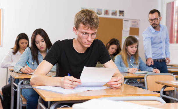 istock Young boy is writing test and thinking about questions at the desk 1070668766