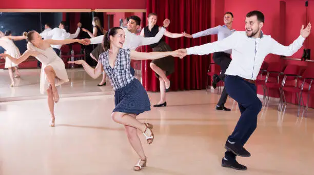 Photo of Ordinary group people dancing lindy hop in pairs