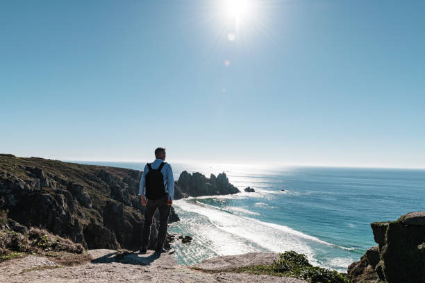 istock Man stood looking out over Pedn Vounder Beach towards Logan's Rock, Cornwall 1070685700