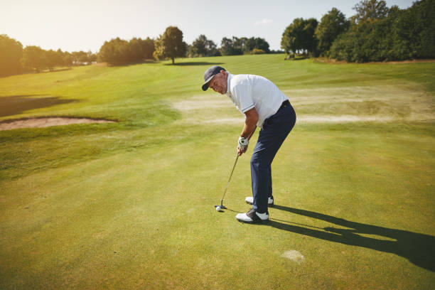 istock Senior man preparing to putt on a golf course green 1070691118