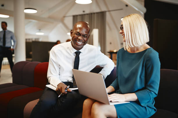 istock Two coworkers laughing together while sitting on an office soafa 1070698730