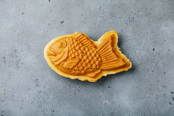 Taiyaki Japanese street food fish-shaped sweet filling waffle on concrete background