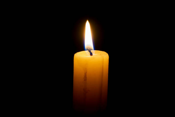 istock burning wax candle on a black background 1070708116