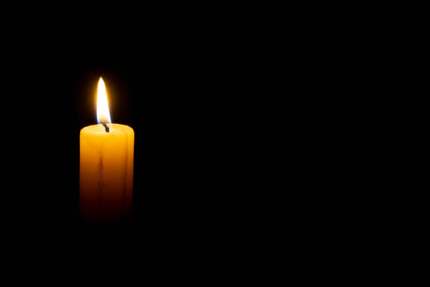 istock burning wax candle on a black background 1070708154