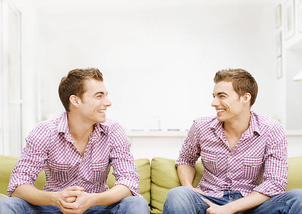 Twins sitting on sofa, smiling  4810 stock pictures, royalty-free photos & images