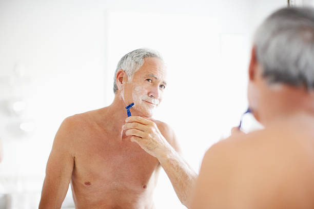 senior man shaving in mirror - shaving men shaving cream mirror imagens e fotografias de stock