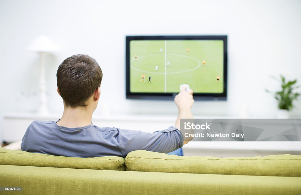 Man watching football on television                Watching TV Stock Photo