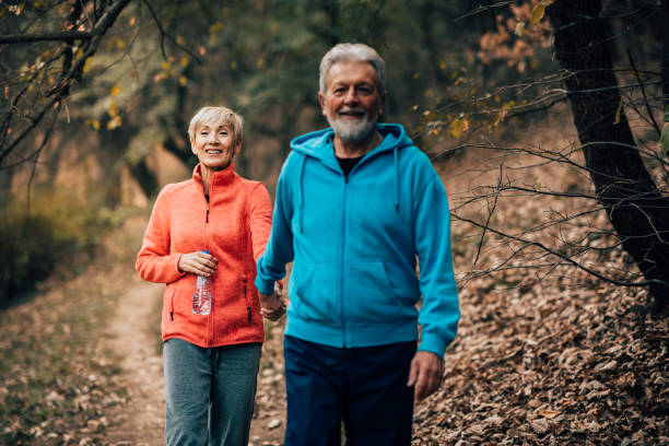istock Happy senior couple taking a walk through a park 1070712468