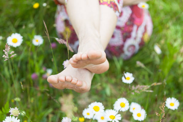 Bare feet in grass with flowers