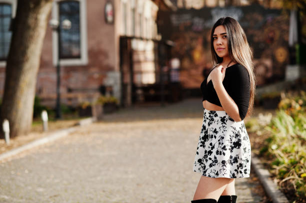 Pretty latino model girl from Ecuador wear on black tops and skirt posed at street.