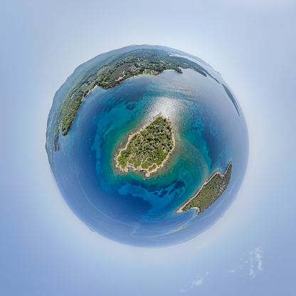 Little planet - spherical view above small island near the sea shore. 360 Drone aerial tiny planet.